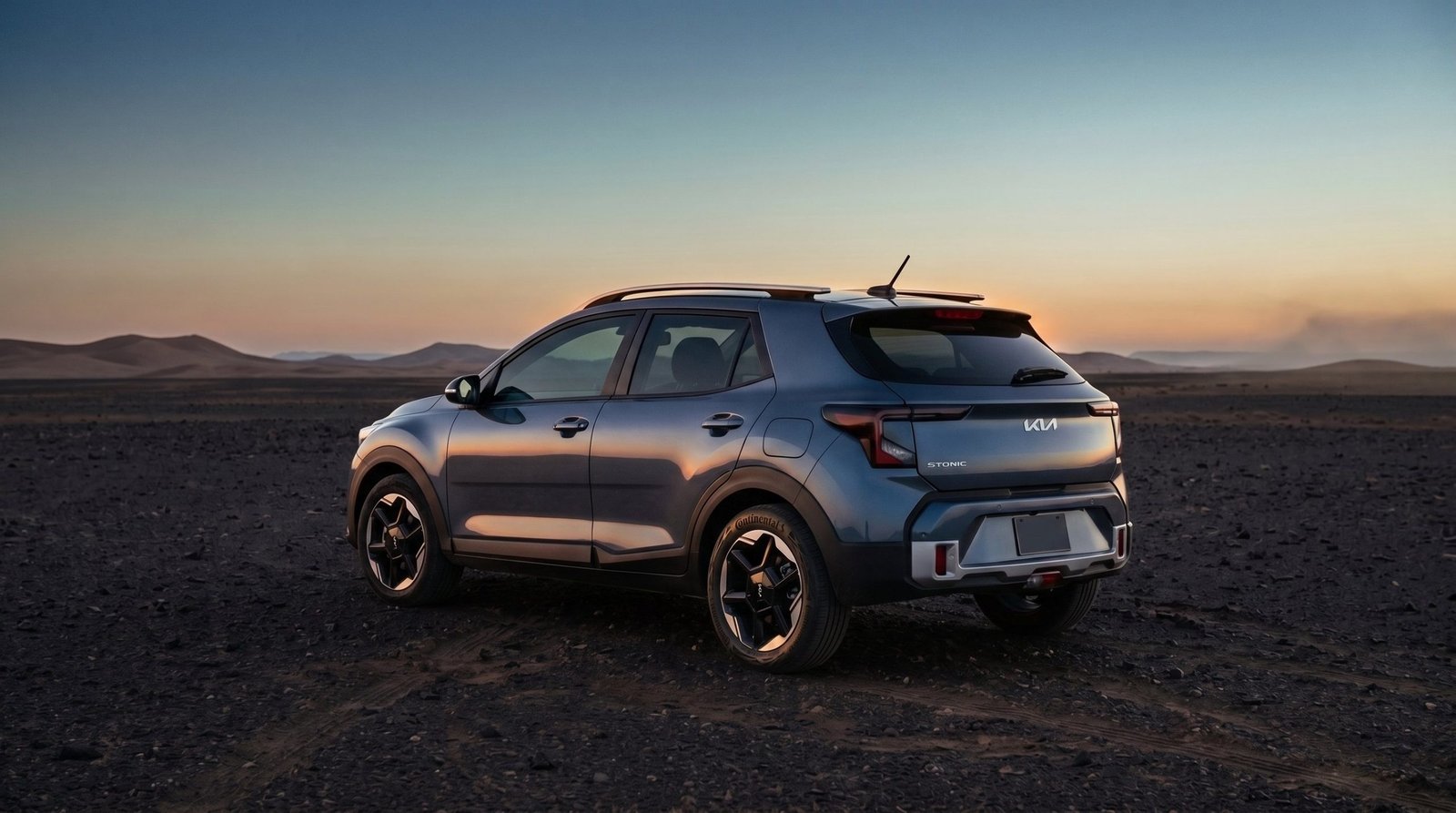 Rear three-quarter view of the Stonic on a dark gravel plain at dusk